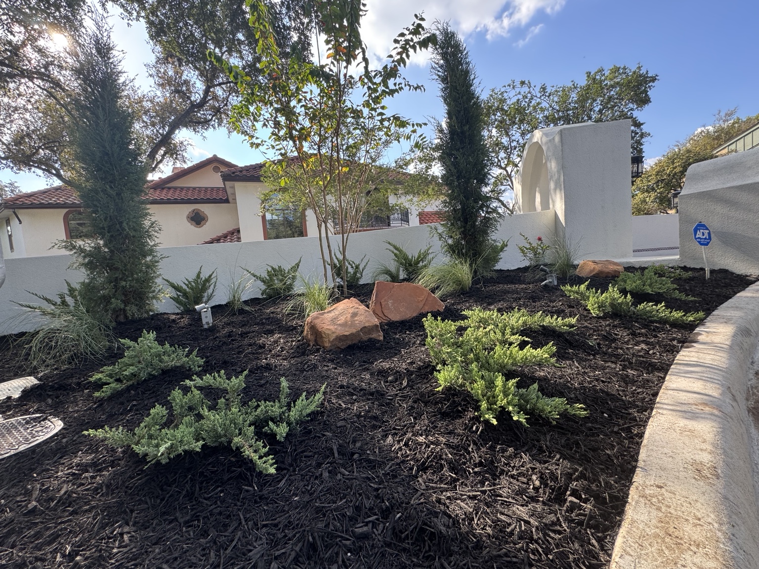 New planting, accent rocks and black mulch in the finished front bed