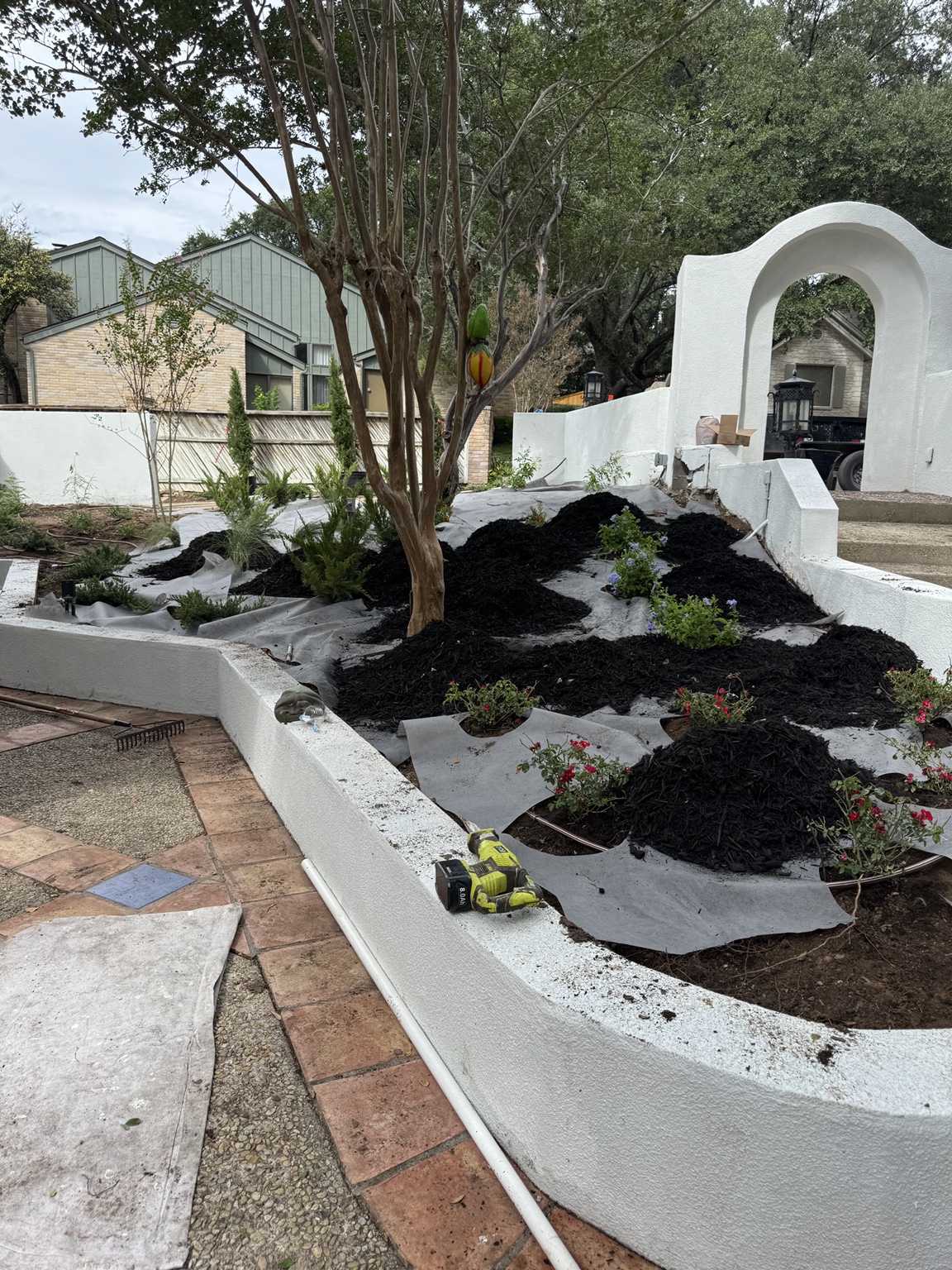 Mulch being installed around courtyard plants